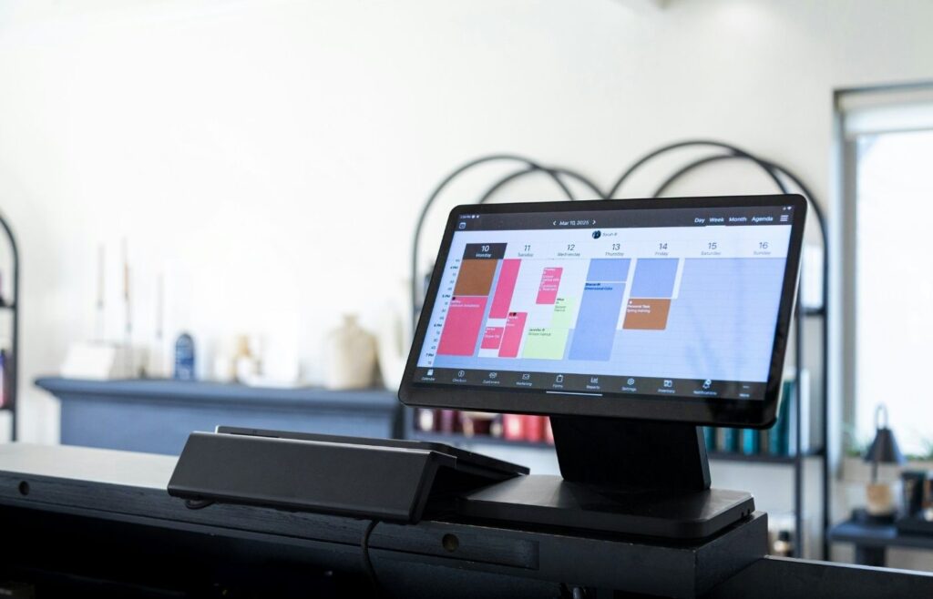 Digital scheduling system displaying a salon appointment calendar at the front desk
