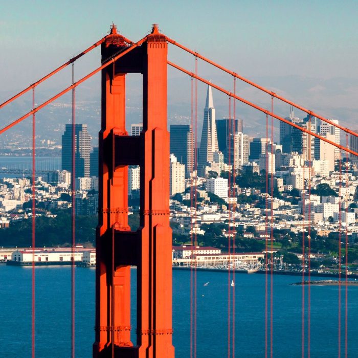Golden Gate Bridge tower with the San Francisco skyline in the background.”