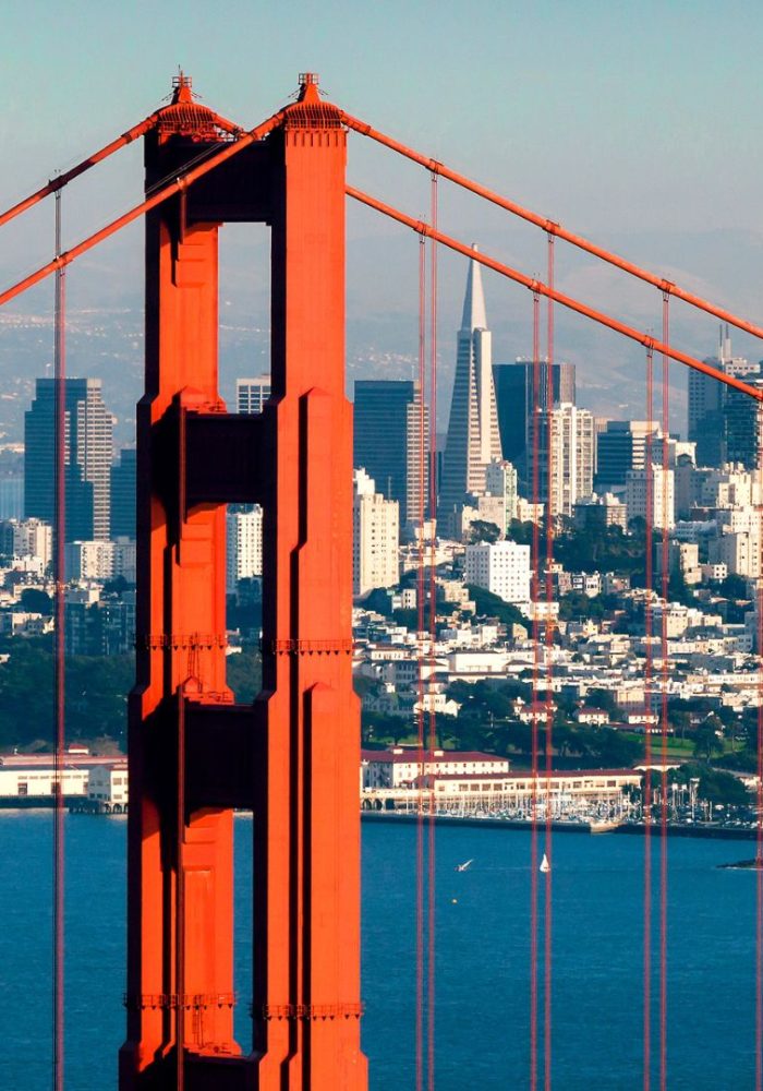 Golden Gate Bridge tower with the San Francisco skyline in the background.”